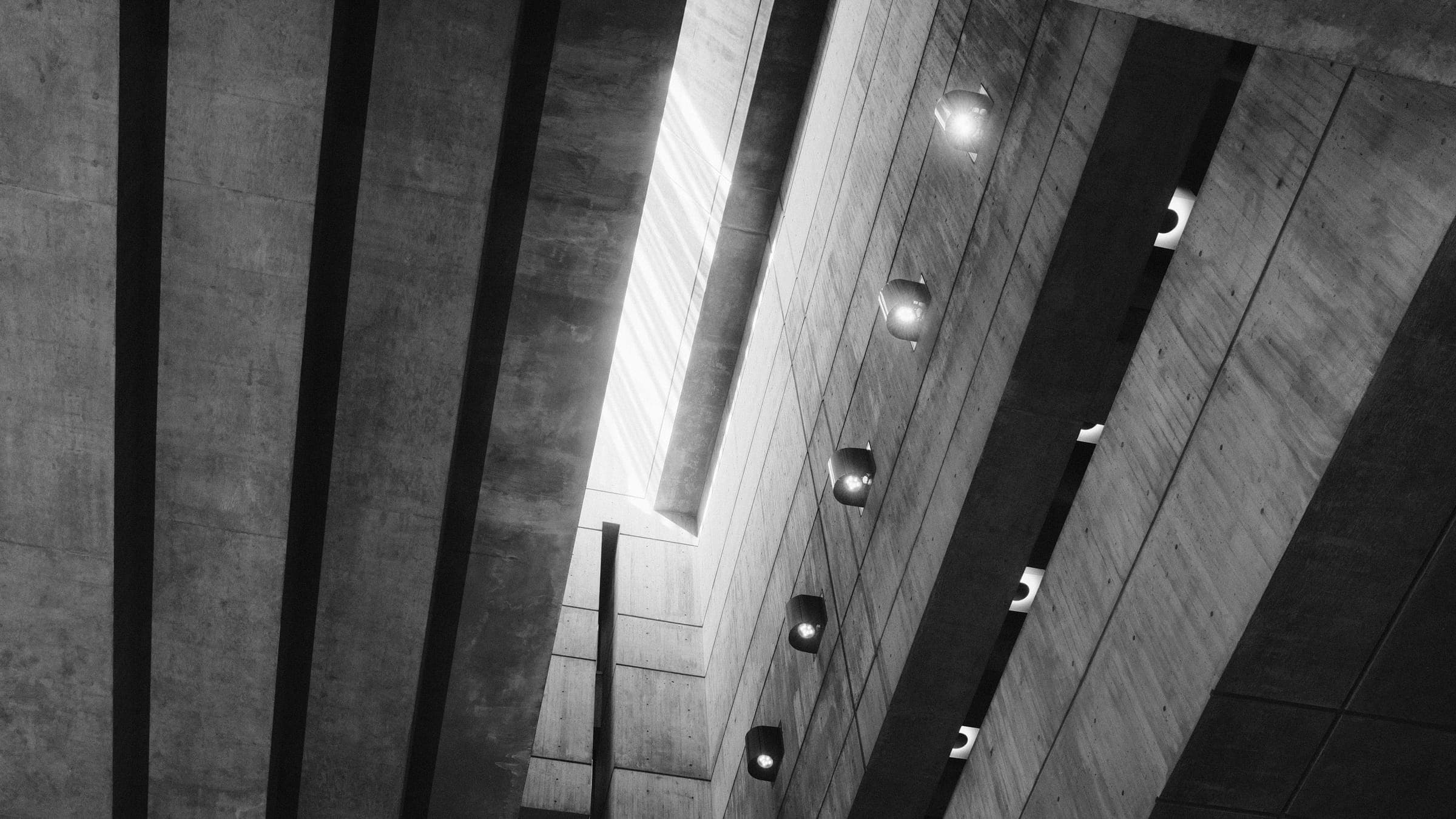 Concrete ribs and a narrow slot of daylight inside a tall interior.